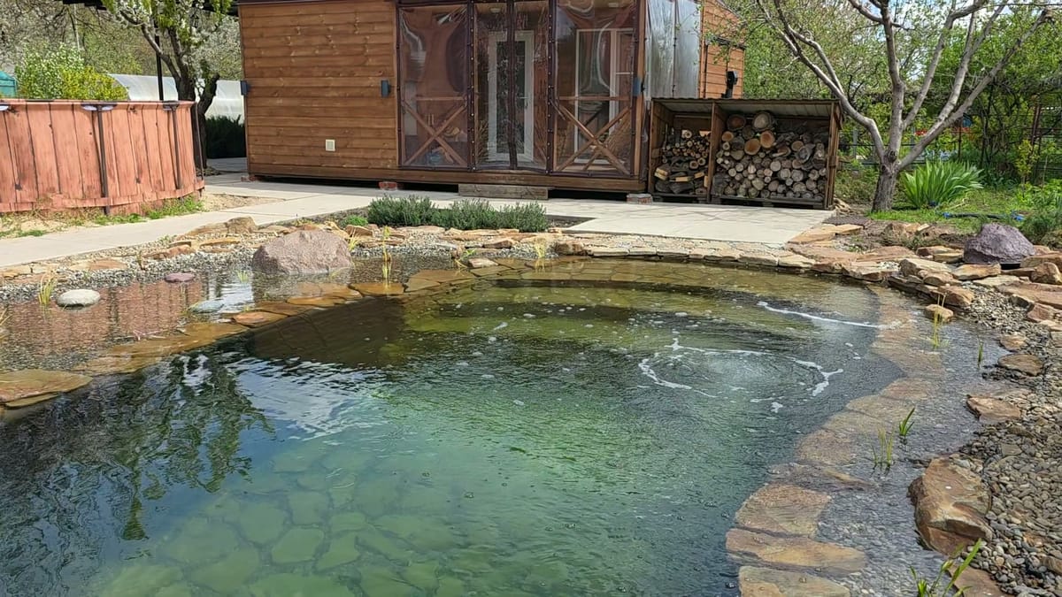 Пруд у бани с прозрачной водой и каменным берегом